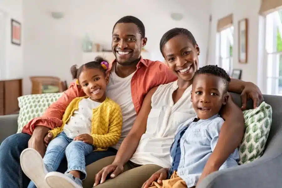 a man and woman sitting on a couch with children